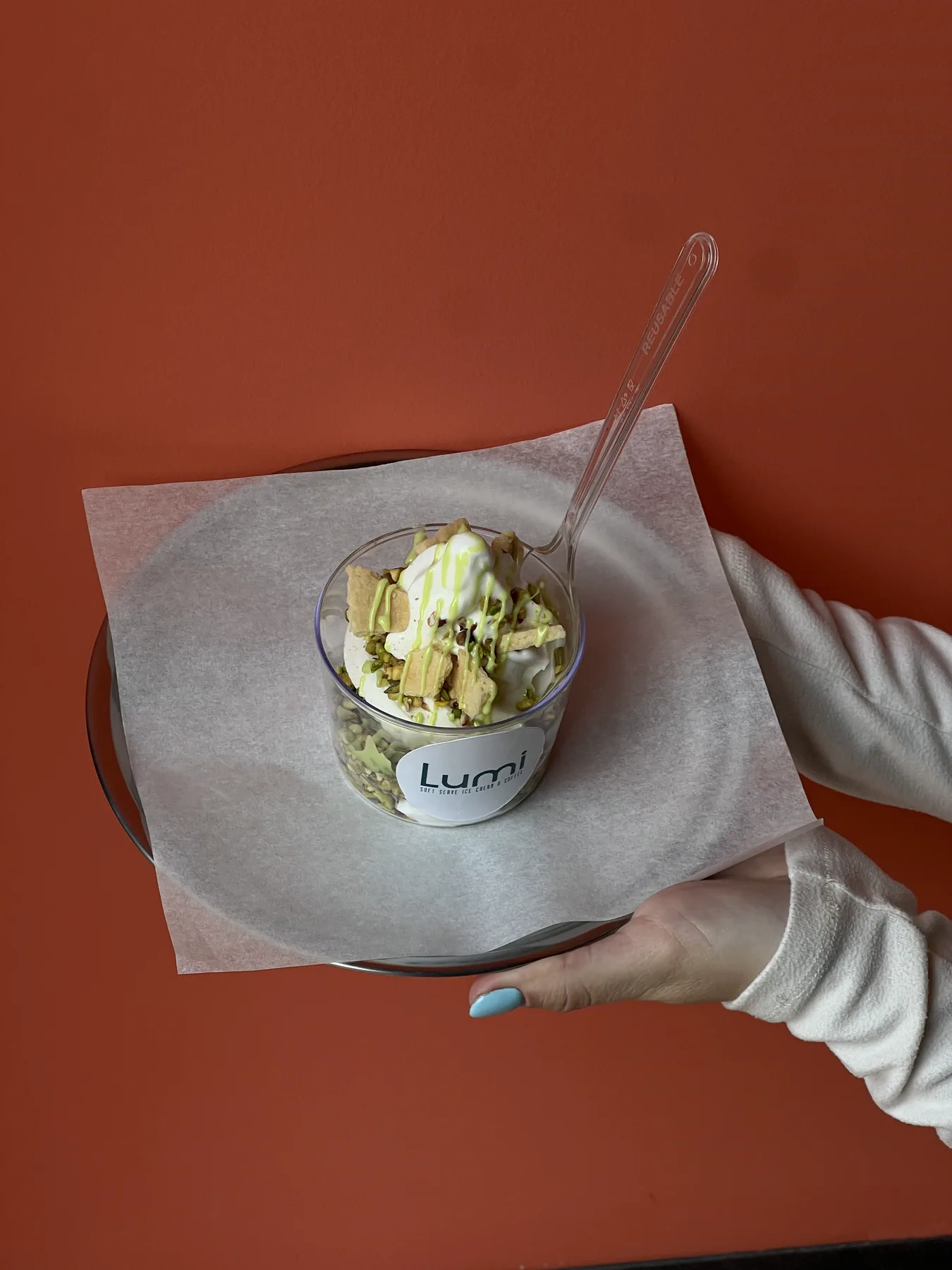 Lumi pistachio soft serve kupasının elde servis edildiği ürün fotoğrafı