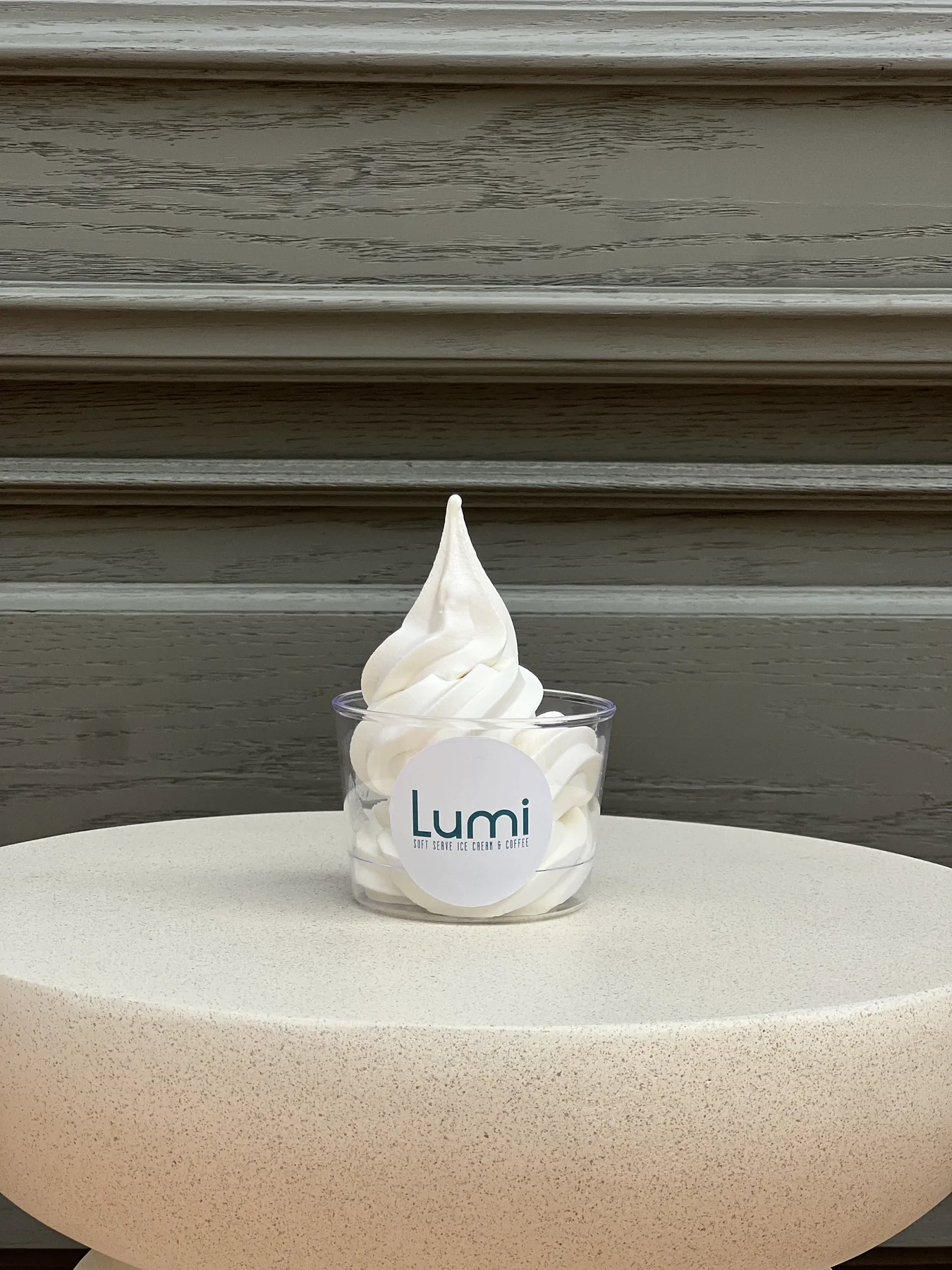 Lumi sade vanilla soft serve kupasının açık renk podyum üzerindeki fotoğrafı
